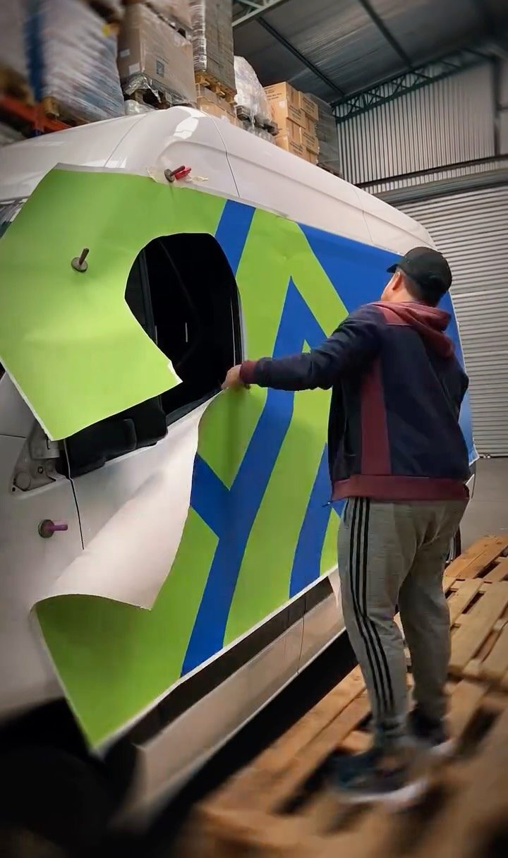 Instalador colocando gráfica en una van